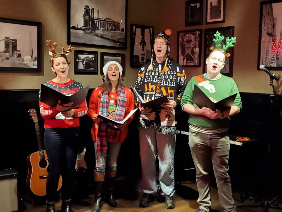The Village Carolers singing in Ugly Sweaters