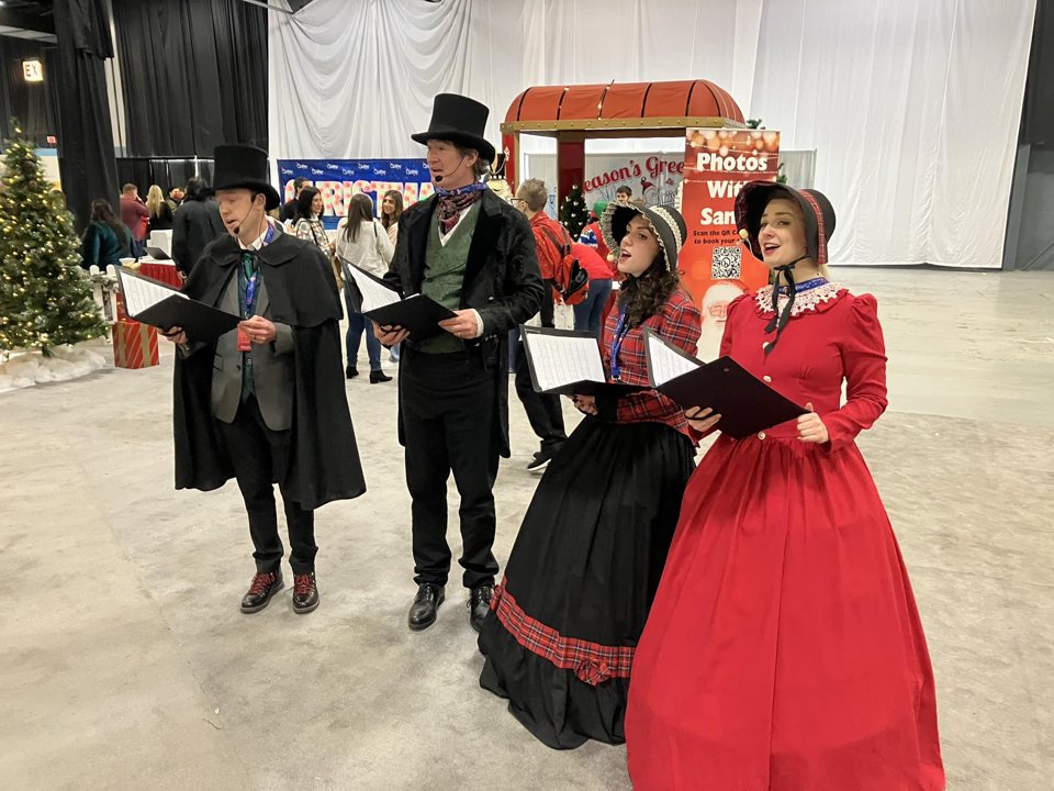 The Village Carolers singing at ChristmasCon