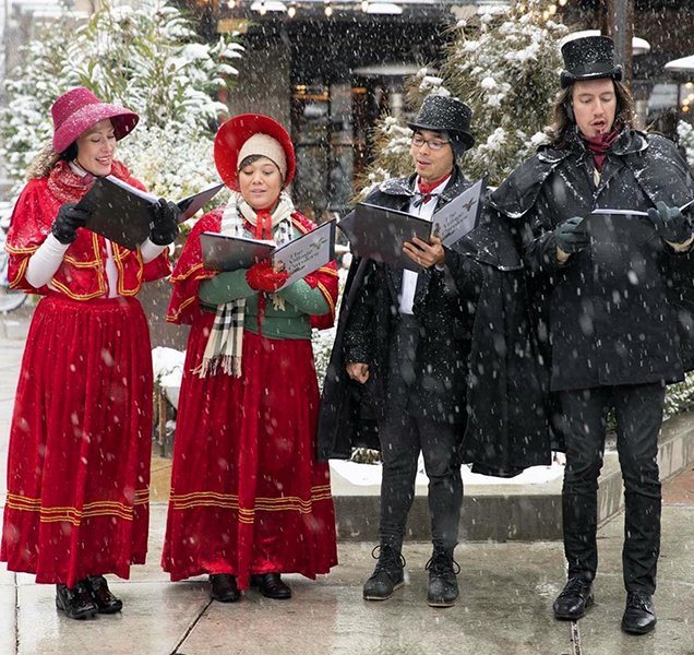 Carolers singing in falling snow