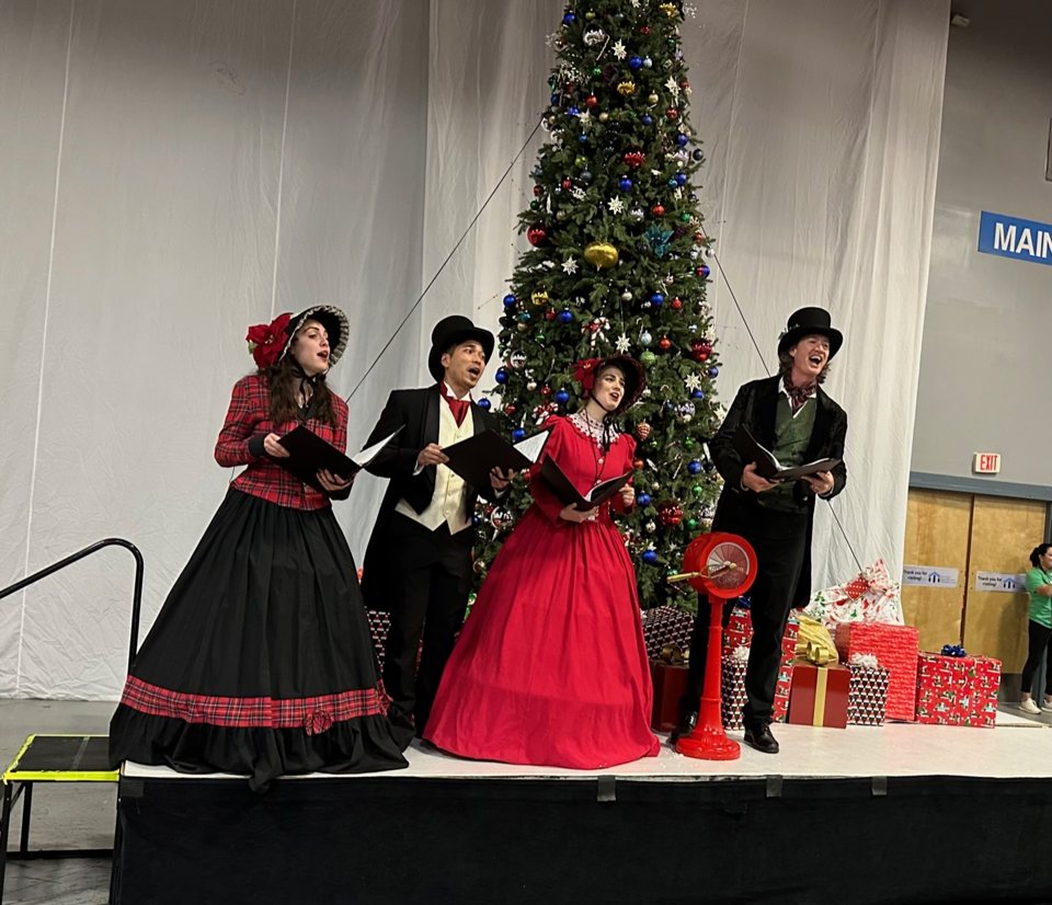 The Village Carolers singing at ChristmasCon